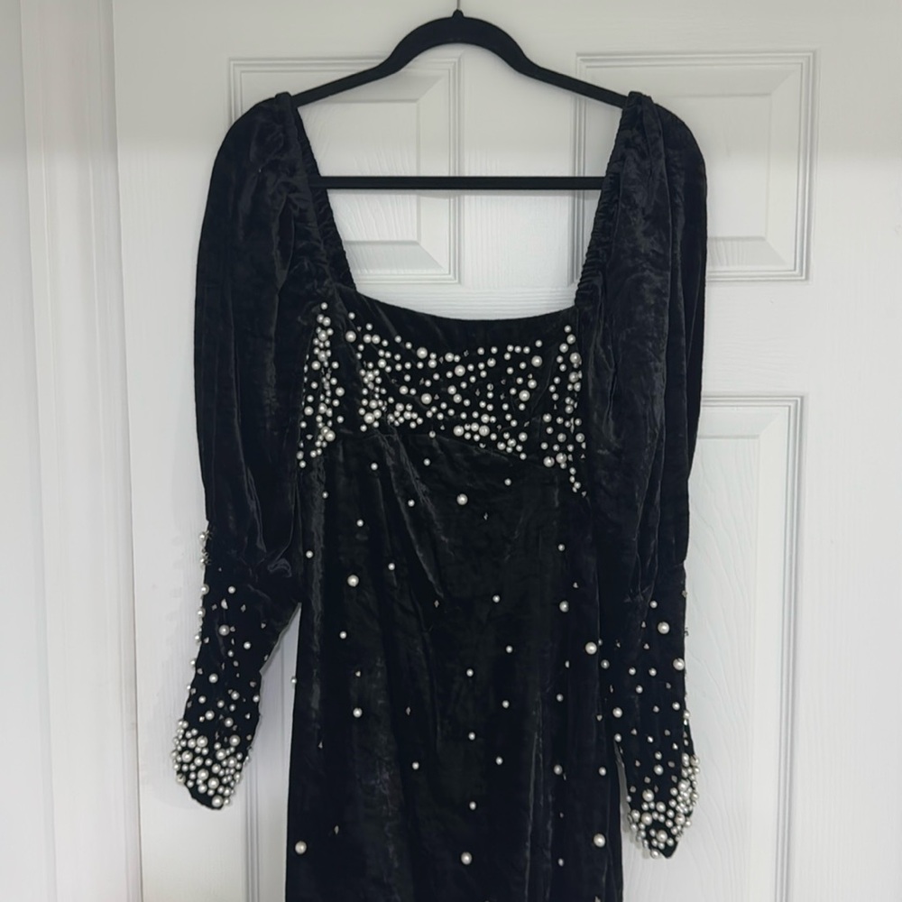 Black velvet dress covered with gems and pearls.